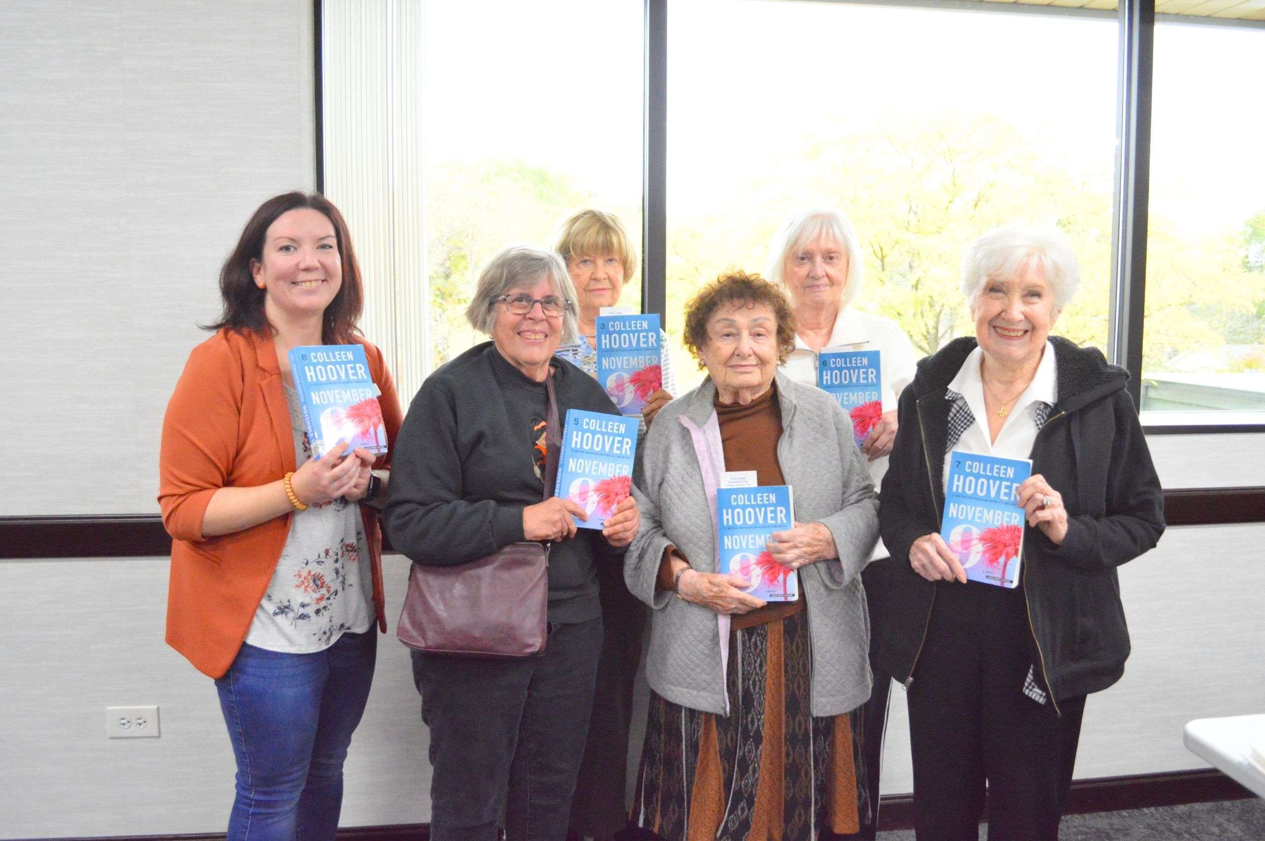 group of women holding up a book